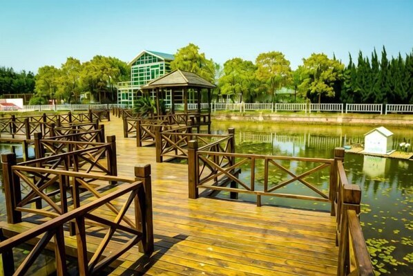Un muelle de madera con un pabellón y un pequeño edificio junto a un lago tranquilo.
