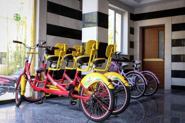 Una fila de bicicletas estacionadas en un interior, con una ventana y una puerta al fondo.