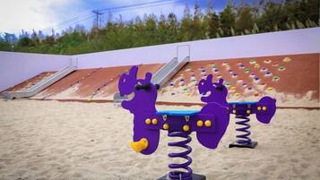 Outdoor playground equipment with slides and climbing holds.