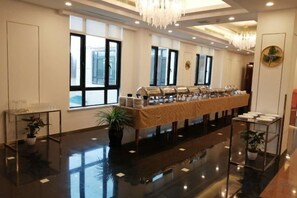 A hotel lobby with a long buffet table, large windows, and a chandelier. - An Hengsha Isiand Resort Hotel (Shanghai)