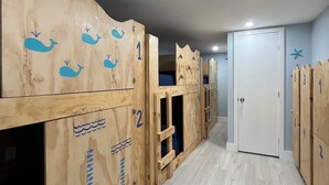 A hallway with wooden lockers numbered 1 to 5, a white door, and a starfish decoration on the wall. - Blue Little Havana (Miami)