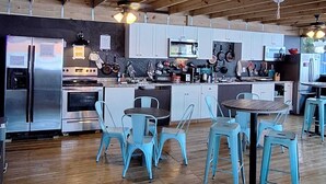 A spacious kitchen with wooden beams, stainless steel appliances, and light blue chairs. - Blue Little Havana (Miami)