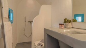 A compact bathroom with a shower, toilet, and a vanity with a mirror. - Cycladic Traditional House with view by MPS (Emporio)