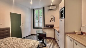 A compact room with a bed, kitchenette, and a window. - Cocooning in Cognac (Cognac)