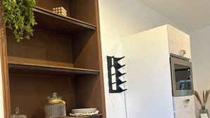A modern kitchen with a wooden countertop, built-in shelves, and a stainless steel refrigerator. - Cocooning in Cognac (Cognac)