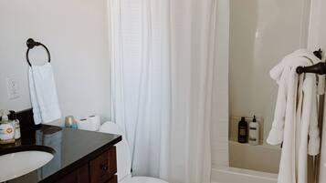 A bathroom with a toilet, sink, and shower area.