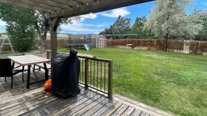 Un espacio de patio cubierto con una parrilla, una mesa y una silla.