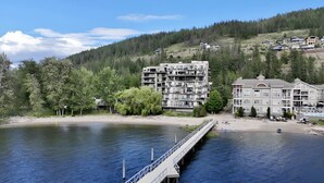 Un hôtel situé au bord de la rivière, avec plusieurs étages, un quai et une plage.