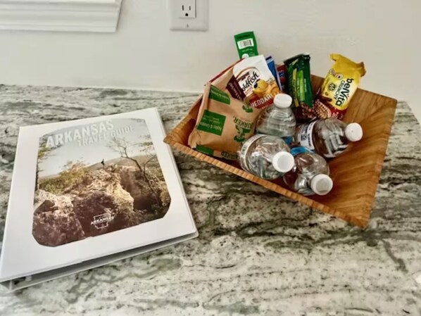 Un libro guía de viajes con el título "Arkansas Travel Guide" sobre una encimera de mármol.