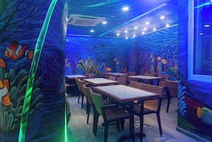 Un área de comedor interior con mesas y sillas dispuestas para los huéspedes.