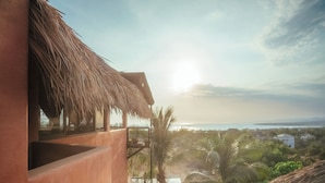 A thatched-roof building with a view of the sea and palm trees. - Penthouse with pool & ocean view (Puerto Escondido)