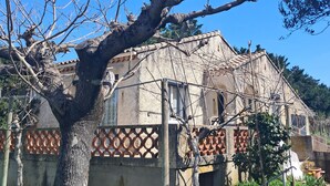 A rustic building with a tree in front, a fence, and a clear blue sky. - Country house near the Ardèche (Saint-Paulet-de-Caisson)
