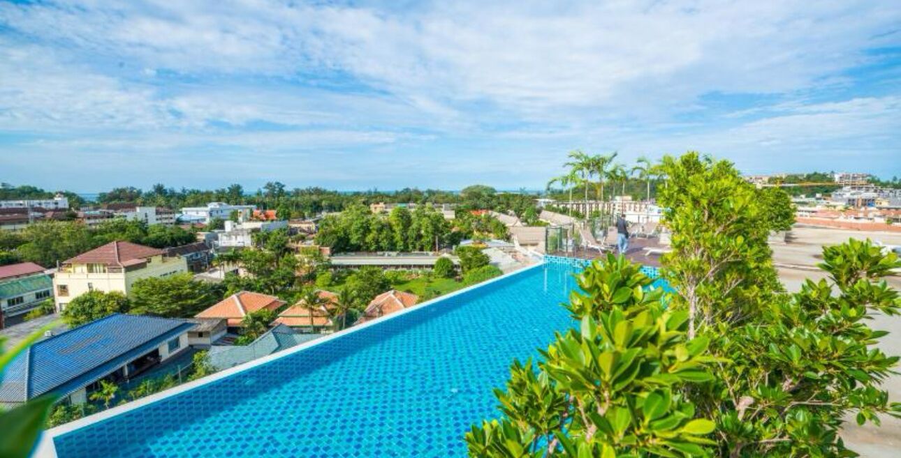 A swimming pool with a view of surrounding buildings and greenery.