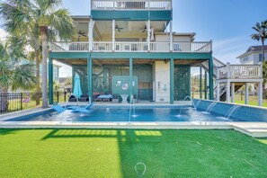 A two-story building with a swimming pool, outdoor seating, and a covered patio area. - Marina & Golf Course Views: Edisto Island Home (Edisto Island)