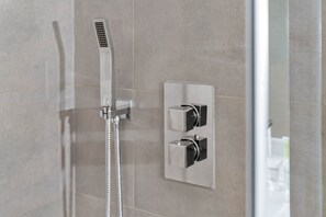 A modern shower with a handheld showerhead and a wall-mounted control panel. - Stylish 4 Bedroom Townhouse - Garden - Balconies - Parking (Birmingham)