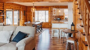 Een gezellig chalet van binnen, met houten details, een eethoek en een keuken.