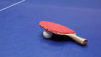 A table tennis paddle on a blue table.
