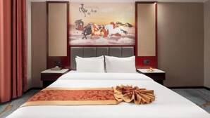 Una habitación de hotel con una cama grande, un cuadro decorativo en la pared y una mesita de noche ordenada.