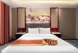A hotel room with a large bed, a decorative wall painting, and a neatly arranged bedside table. - Yuzhou Peace Hotel (Hotan City)
