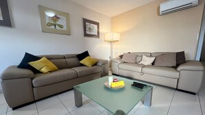 A living room with two sofas, a glass coffee table, and a floor lamp. - Marina Portorož Family Friendly Apartment 1 (Piran)