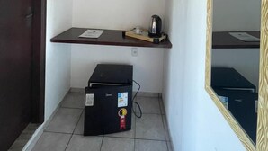 A small room with a desk, a shelf, a mirror, and a black box on the floor. - Chill Inn Pousada Paraty (Paraty)