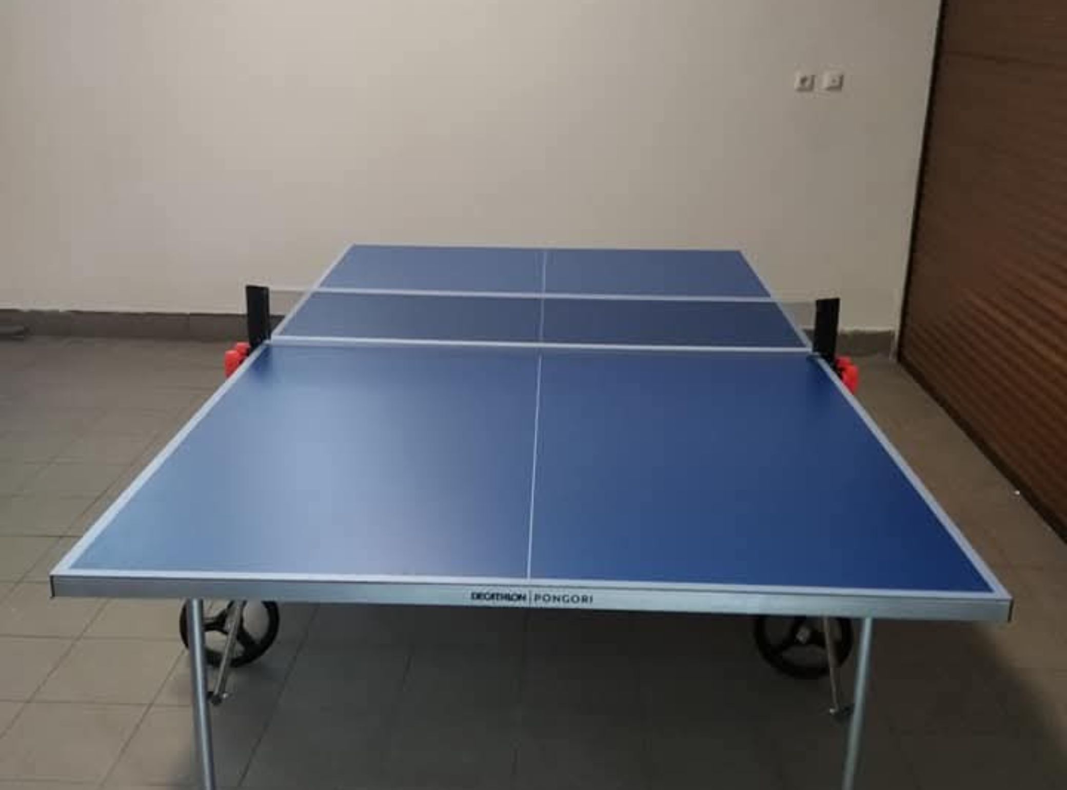 A ping pong table with wheels, labeled 'Decathlon Pongori'.