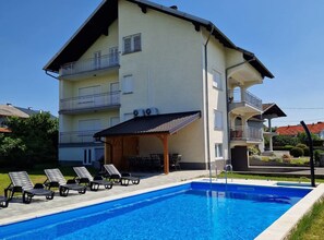 A two-story building with a swimming pool, outdoor seating, and a covered patio area. - Holiday Home Dugo Selo M&A (Dugo Selo)
