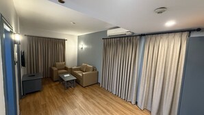 A modern living room with a sofa set, a small table, and a TV. - AL SHARQ HOTEL L L C (Sharjah)