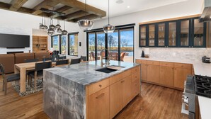 Una cocina moderna con una isla grande, armarios de madera y una estufa integrada.
