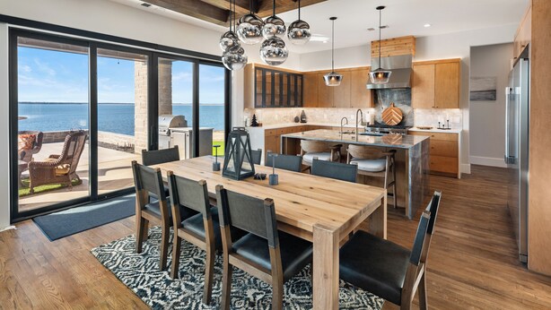 Una cocina moderna con armarios de madera, una isla grande y vista al océano.