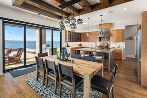 Una cocina moderna con armarios de madera, una isla grande y vista al océano.