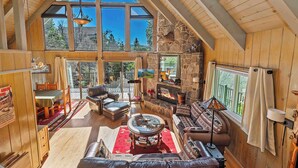 Un vaste espace de vie de style loft, doté d’une cheminée en pierre, de grandes fenêtres et d’un plafond haut.