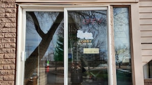 Una finestra con un cartello che indica 'Lodge Lobby' e un numero di telefono.