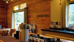 A cozy cabin interior with a wooden interior, a kitchen area, and a seating area with a sofa and a dining table. - Cabana Fruta Fina - Urubici - SC (Urubici)