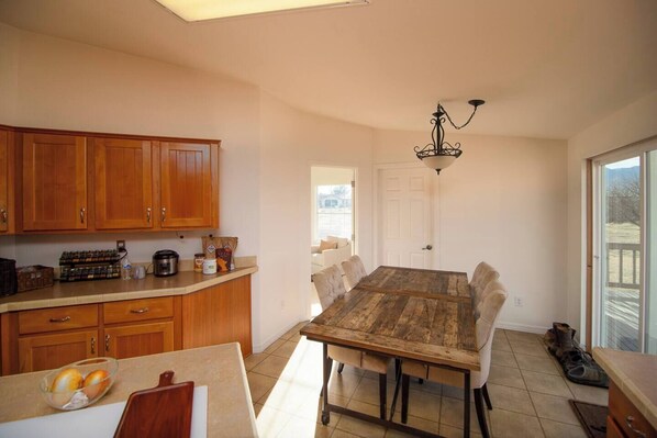 A kitchen with wooden cabinets, a dining table, and a chandelier.