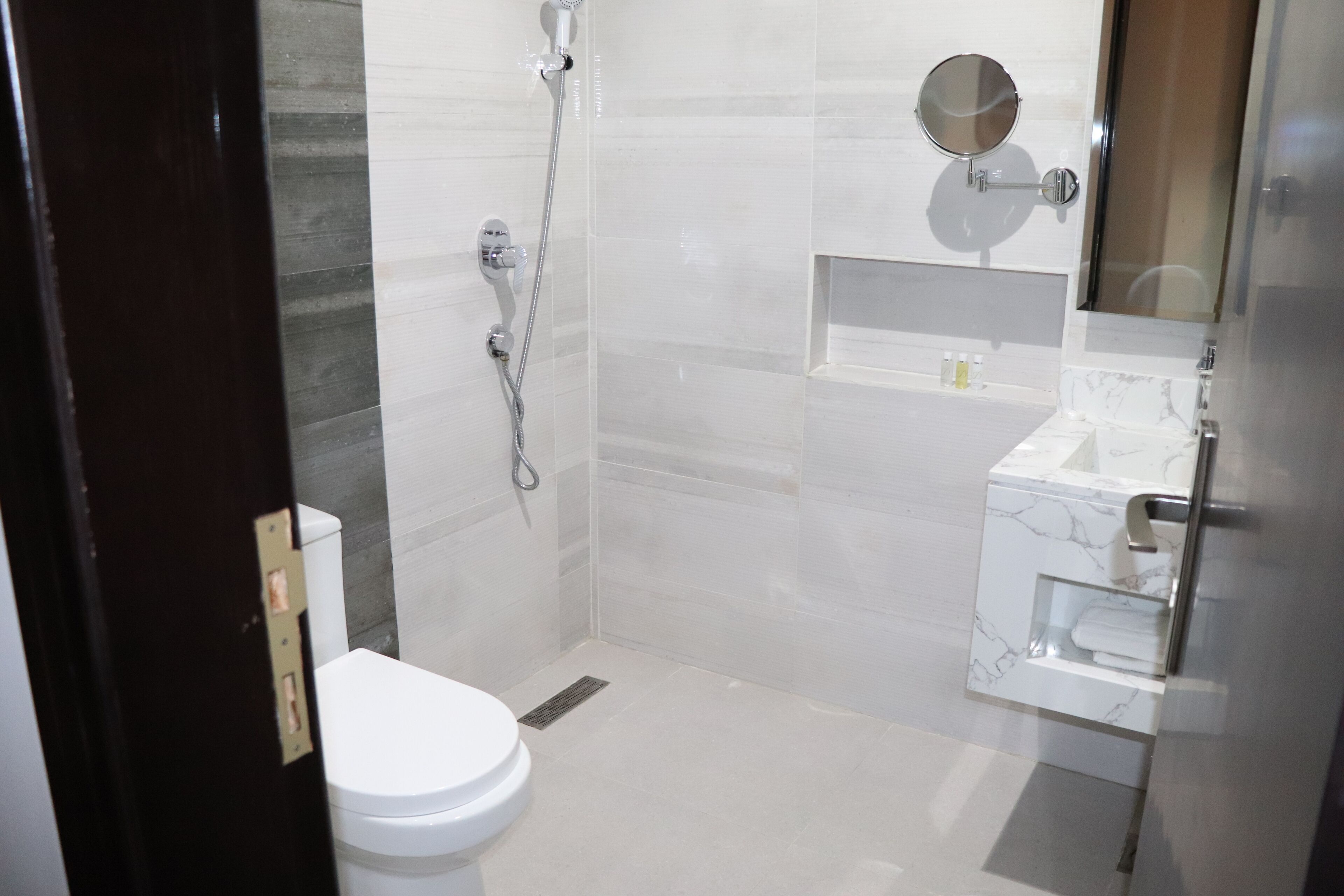 A modern bathroom with a toilet, shower, and sink.