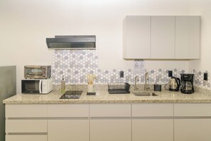 Una cucina attrezzata con forno a microonde, tostapane, macchina del caffè e lavello.