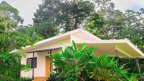 A small, single-story building surrounded by lush greenery.