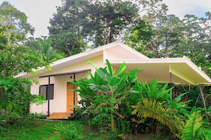 A small, single-story building surrounded by lush greenery.