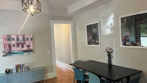 Un coin repas avec une table en bois foncé, des chaises de couleur turquoise et un meuble bleu clair.
