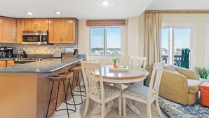 Una cocina moderna con armarios de madera, microondas integrado y una isla grande con taburetes de bar.
