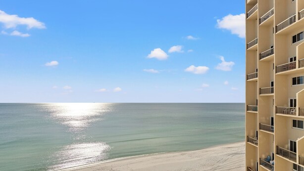Vista de una playa desde un edificio de gran altura con balcones que dan al océano.