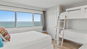 A bedroom with a large window overlooking the sea, a bunk bed, and a ladder. - Pinnacle Port,  A-708 (Panama City Beach)