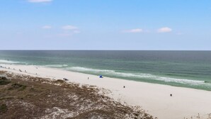 A beach with a sandy shore, a few people, and a clear sky. - Pinnacle Port,  A-708 (Panama City Beach)