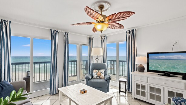 A spacious balcony with a view of the ocean, a comfortable seating area with a TV, and a ceiling fan. - Pinnacle Port, B3-405 (Panama City Beach)