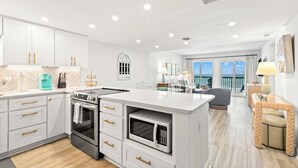 A modern kitchen with white cabinetry, stainless steel appliances, and a central island. - Pinnacle Port, C1-401 (Panama City Beach)