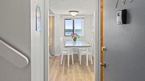 Pasillo que conduce a un comedor con vistas al exterior, una puerta con la etiqueta "701" y un interfono instalado en la pared.