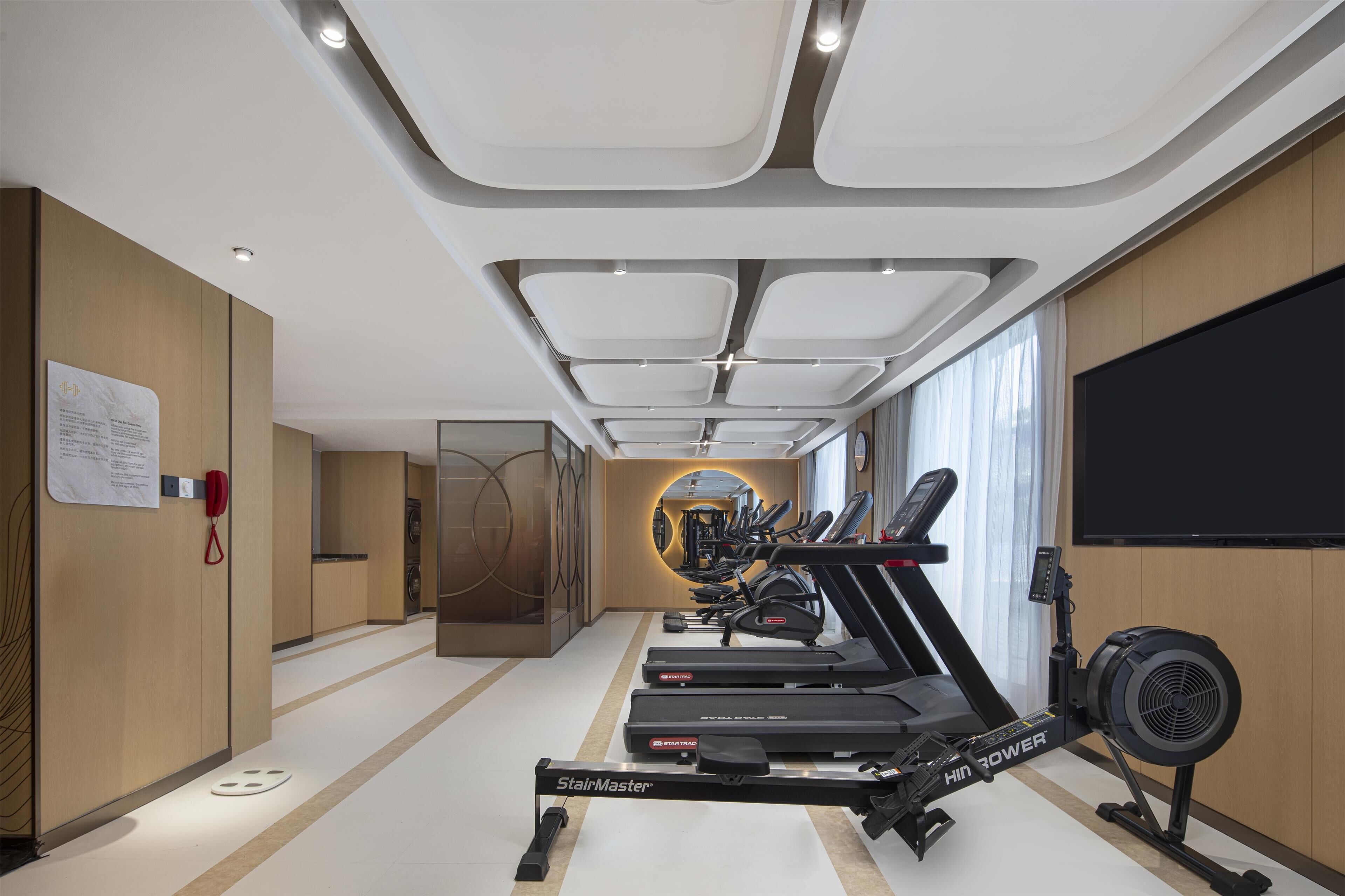 Et moderne fitnesscenter med løbebånd, spinningcykel og romaskine.