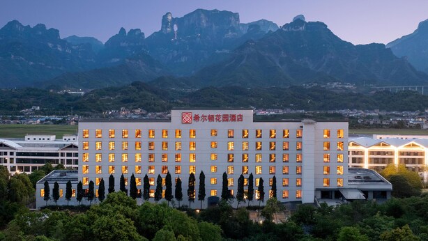 A hotel with a modern design, featuring a flat roof and a series of windows. - Hilton Garden Inn Zhangjiajie Tianmen Mountain (Zhangjiajie)