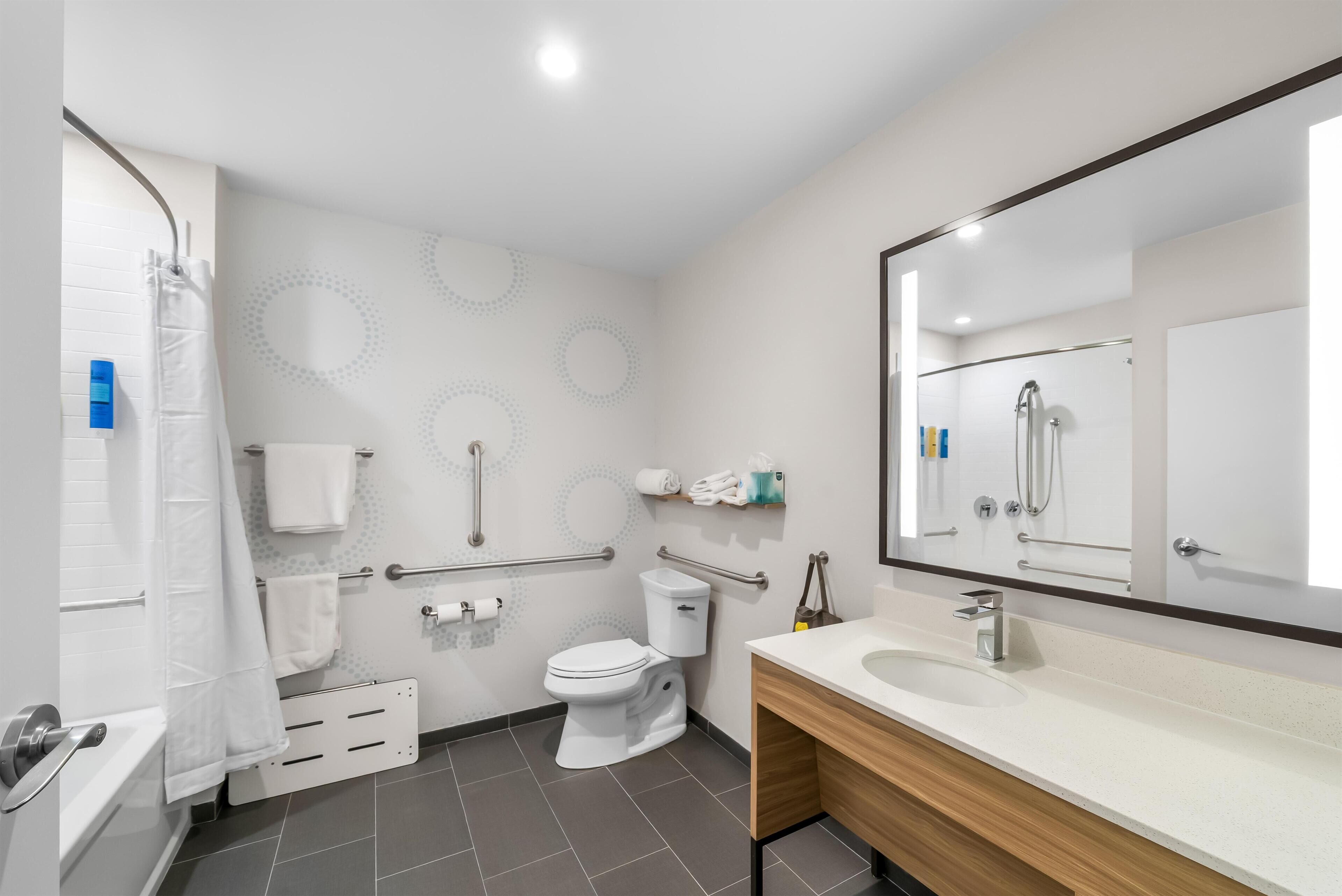 A modern bathroom with a toilet, sink, and shower.